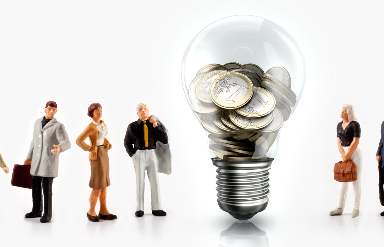 Miniature people in front a light bulb with Euro coins inside