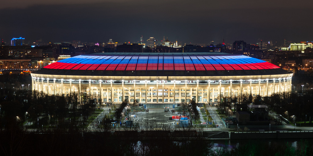 Luzhniki Stadium in Moscow, the final venue of the 2018 Soccer World Cup, at night. The stadium's roof is illuminated in the colors of the Russian flag.