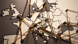 Das Foto zeigt eine Europakarte mit Pins auf den einzelnen Ländern. Die Pins sind mit einem Faden untereinander verbunden.