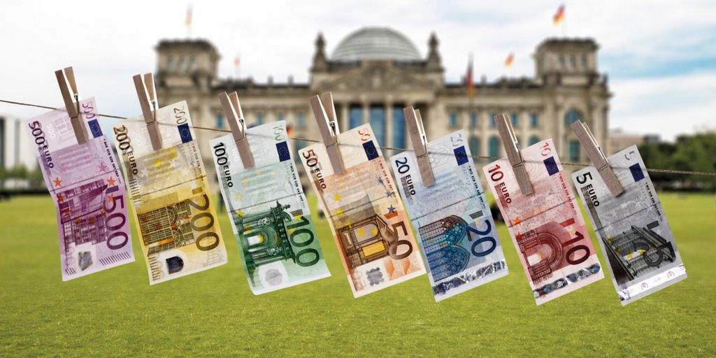 Geldscheine hängen an einer Wäscheleine vor dem deutschen Reichstag.