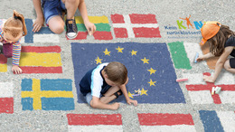 Kinder malen EU-Flaggen auf eine Straße