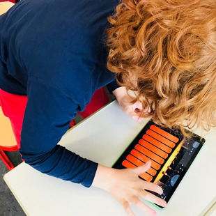 Ein Junge musiziert an einem tablet