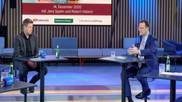 Grünen-Bundesvorsitzender Robert Habeck und Bundesgesundheitsminister Jens Spahn sitzen sich in einem Studio des Rundfunks Berlin-Brandenburg beim "Polittalk aus der Hauptstadt" an weit auseinanderstehenden Einzeltischen gegenüber. Jens Spahn hält ein Mikrofon in der Hand und spricht, während Robert Habeck zuhört.