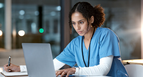 Eine Pflegerin arbeitet am Laptop