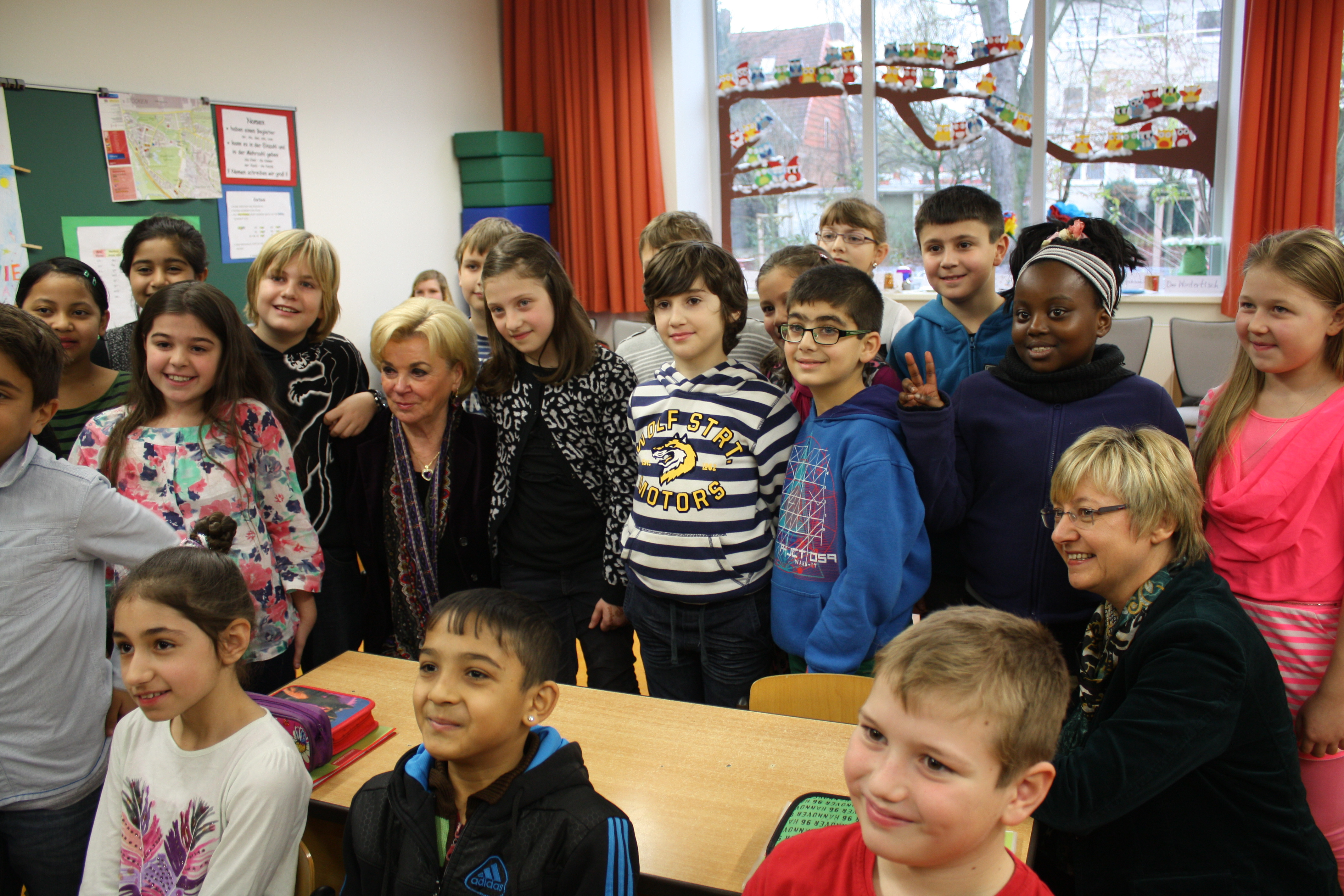 Liz Mohn surrounded by many students in a classroom