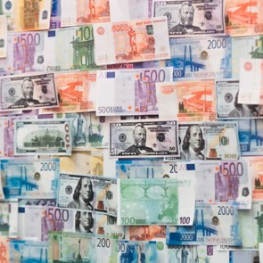 Geldscheine verschiedener Nationen hängen an einer Wand