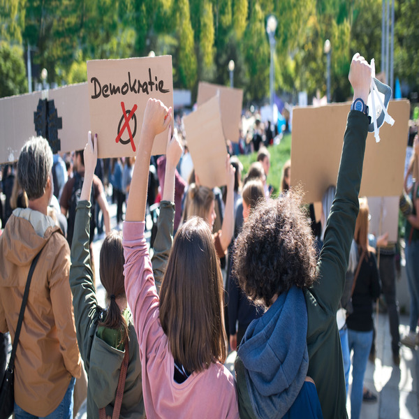 Rear view of people with placards and posters on global strike for climate change.(© Montage: © Halfpoint - stock.adobe.com)