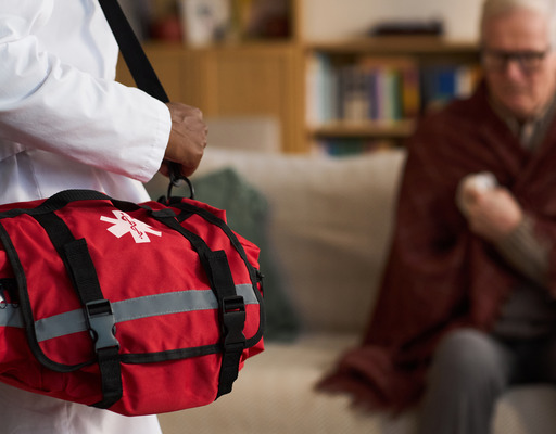 Ein Mann hält eine rote Arzttasche fest