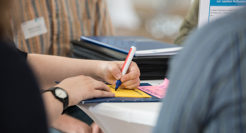 Hand, die mit einem Stift schreibt