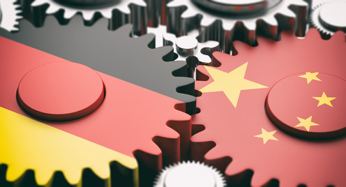 China- und Deutschland-Flaggen auf Metallzahnräder.