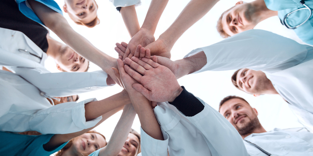 Junge Ärtz:innen geben sich die Hand.