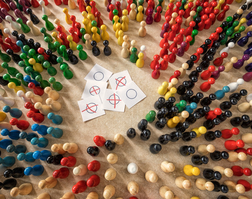 Stimmzettel, umringt von Spielfiguren