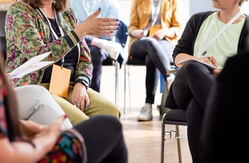 Menschen sitzen am Tisch bei einer Veranstaltung