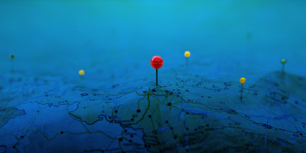 Pins on a geographic map curved like mountains