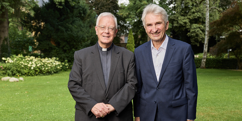 Matthias König, Weihbischof im Erzbistum Paderborn, und Andreas Pinkwart, Vorstand der Bertelsmann Stiftung, posieren am Rande des Besuchs Königs in Gütersloh für ein gemeinsames Foto.