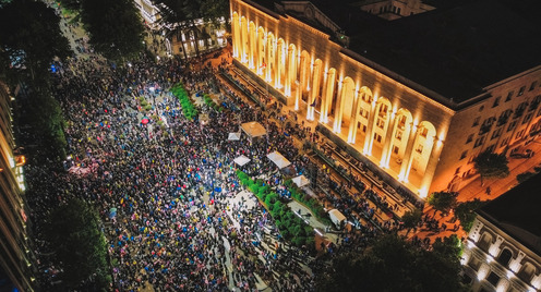 A crowd in front of an illuminated building