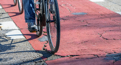 Fahrrad fährt auf einem beschädigten Radweg
