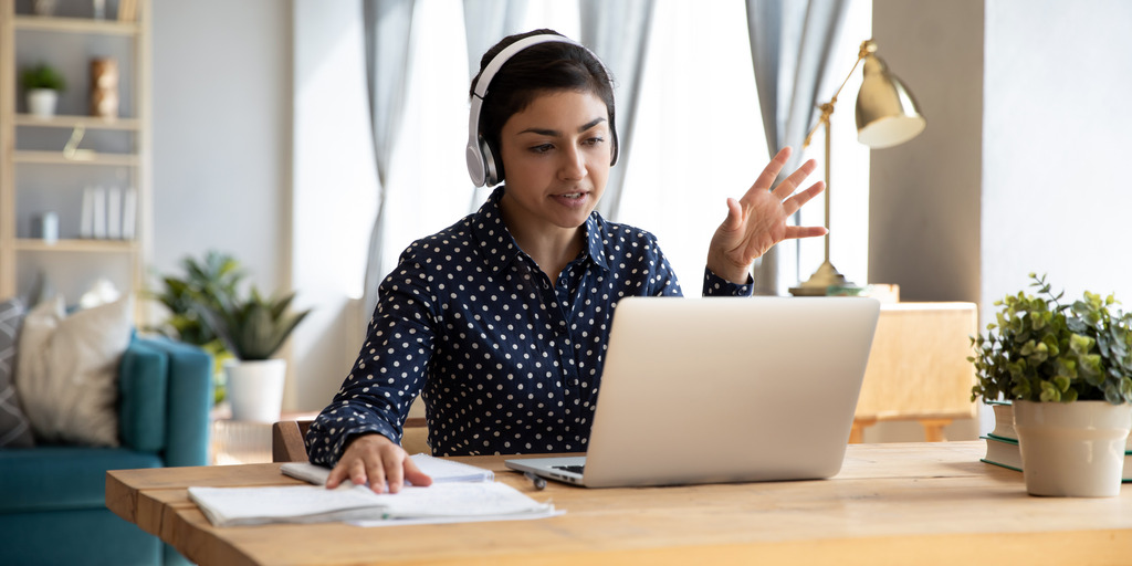 Junge Frau sitzt am Schreibtisch mit Notebook