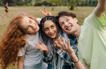 Auf dem Foto sind drei junge Menschen zu sehen, die sich gemeinsam freuen