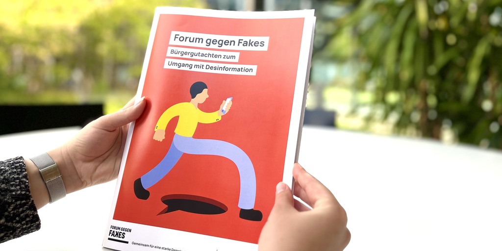 Person hält das Bürgergutachten zwischen zwei Händen