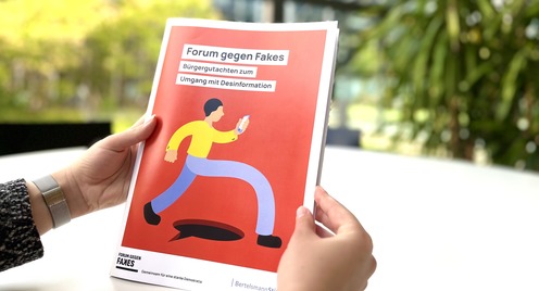 Person hält das Bürgergutachten zwischen zwei Händen