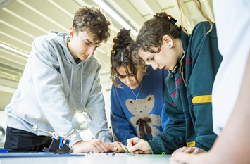 Kleiner Gruppe junger Menschen arbeitet gemeinsam an einem Problem