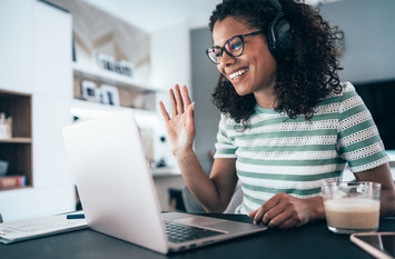 Frau sitzt am Laptop und spricht