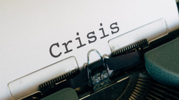 Schreibmaschine mit der Aufschrift "Crisis".