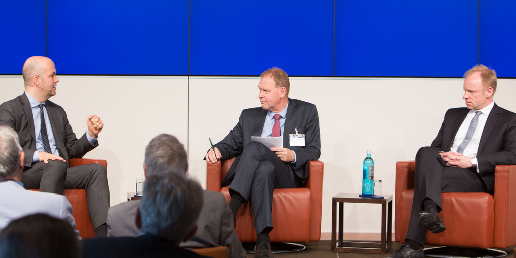 Marcel Fratzscher, Aart De Geus und Clemens Fuest sitzen auf dem Podium der Veranstaltung in Berlin. Marcel Fratzscher spricht, während die anderen beiden Männer zuhören.