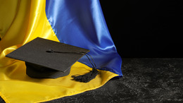 Studentenhut liegt auf einer ukrainischen Flagge