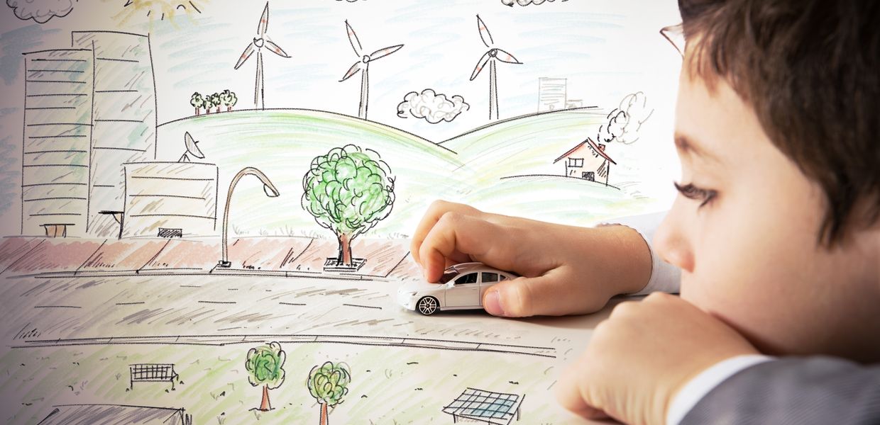 (© alphaspirit / Shutterstock Images) Ein Junge spielt mit einem Spielzeugauto auf einer gezeichneten Leinwand.