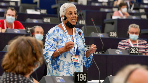 Eine Teilnehmerin steht bei einer Sitzung der Konferenz zur Zukunft Europas im September 2021 im Europäischen Parlament in Straßburg in den Sitzreihen der Abgeordneten an einem Mikrofon und spricht.