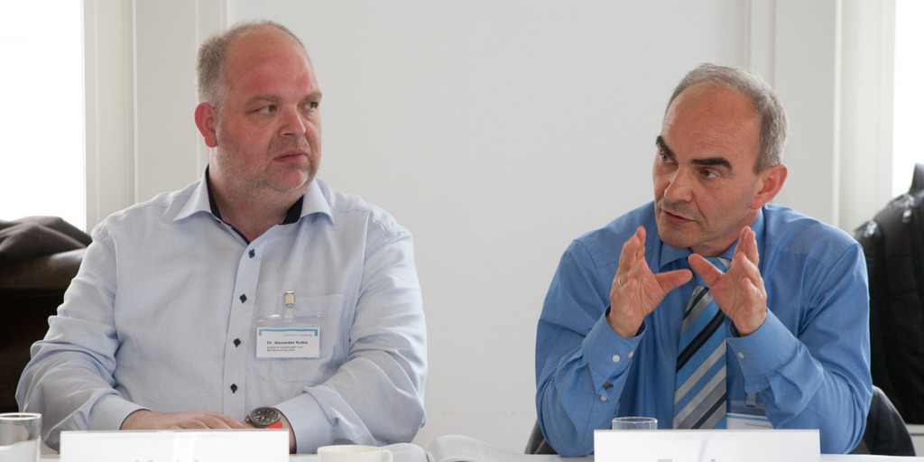 Dr. Johann Fuchs und Dr. Alexander Kubis sitzen auf dem Podium und stellen ihre Studie vor