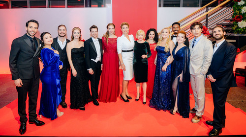Nach dem Abschlusskonzert des NEUE STIMMEN-Meisterkurses 2023 posieren die Sänger:innen mit NEUE STIMMEN-Präsidentin Liz Mohn und Meisterkurs-Dozentin Annette Dasch im geschmückten Foyer der Bertelsmann Stiftung in Gütersloh für ein Gruppenfoto.