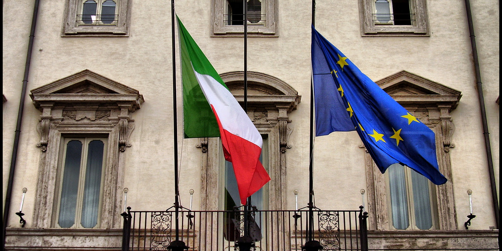 An einer Fassade in Rom wehen die italienische und die EU-Flagge nebeneinander.