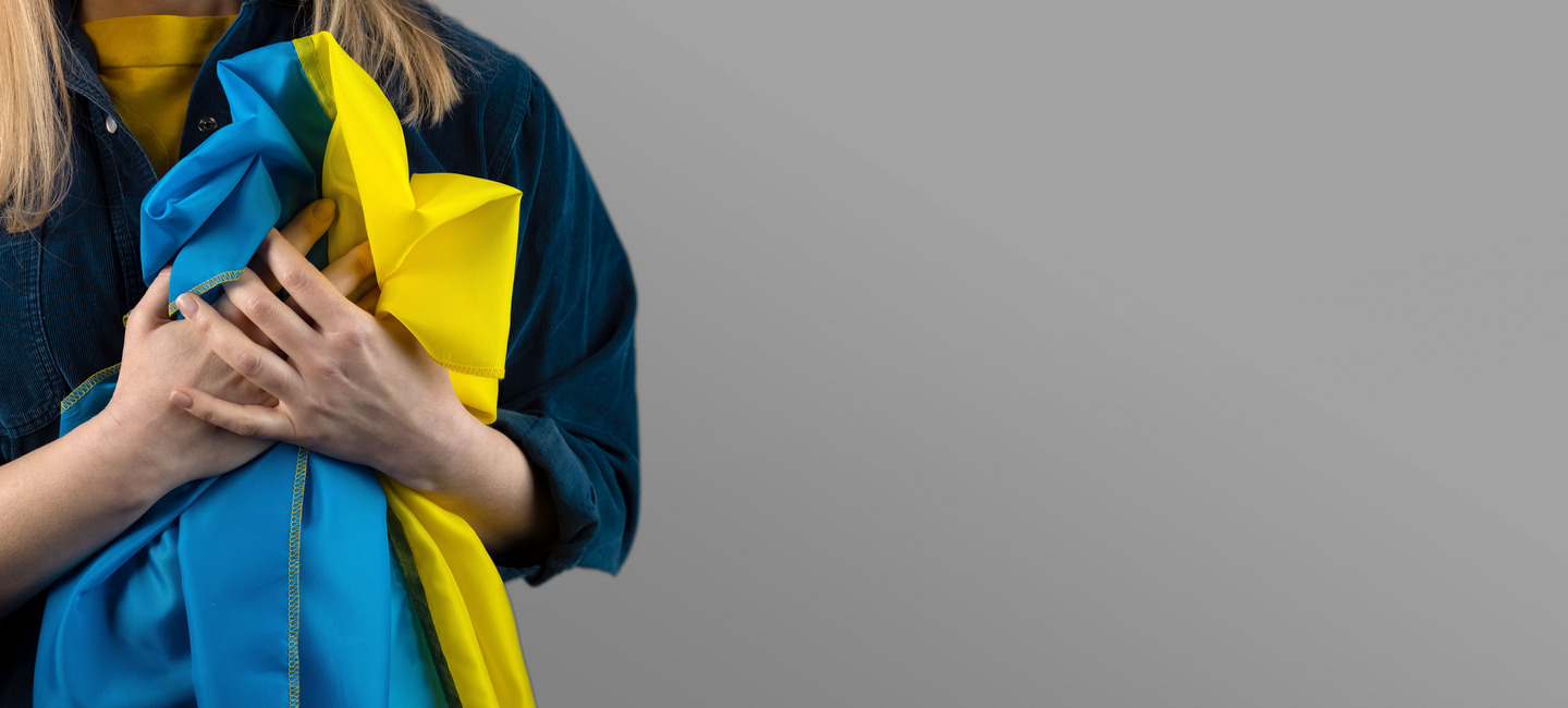 Frau hält Ukraine-Flagge ans Herz.