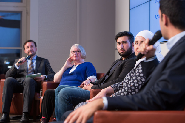 Moderator Herr Thamm im Gespräch mit Migranten und weiteren Personen