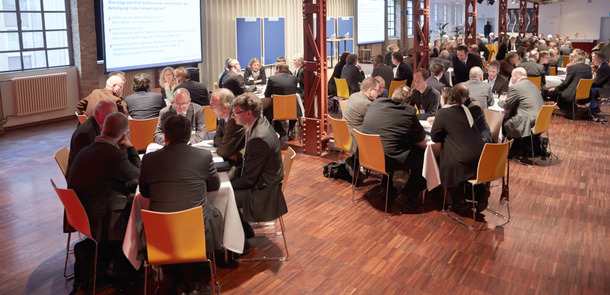 Menschen diskutieren an runden Tischen