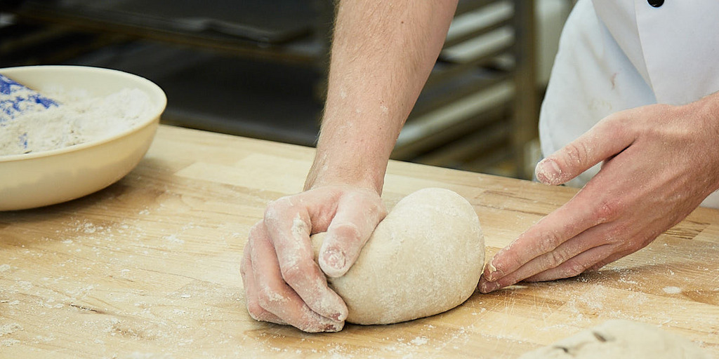 Bäcker rollt Teig