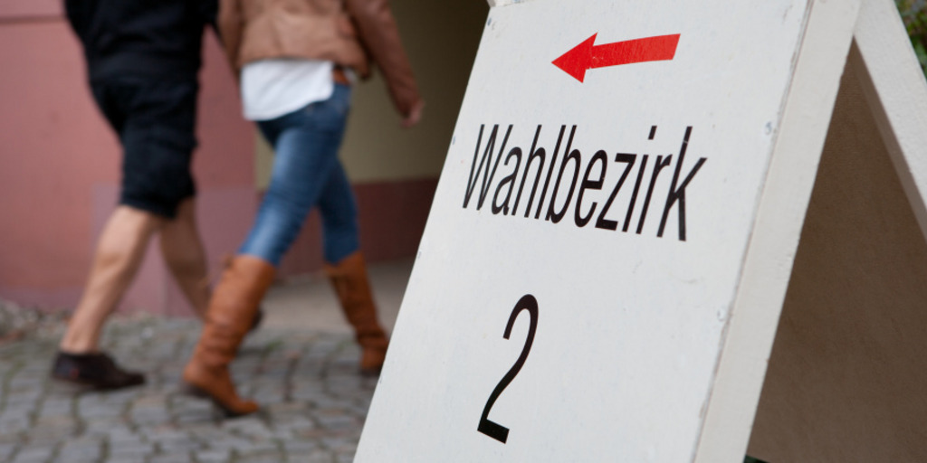 Zwei Wähler betreten ein Wahllokal.