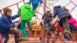 Kinder klettern auf einem Klettergerüst