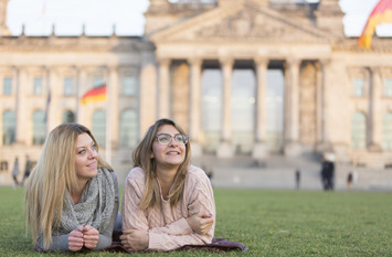 Zwei Frauen auf dem Rasen vor dem Reichstagsgebäude in Berlin