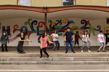Auf einer Outdoor Bühne tanzen Jugendliche. Die Bühne ist mit Grafite besprüht.