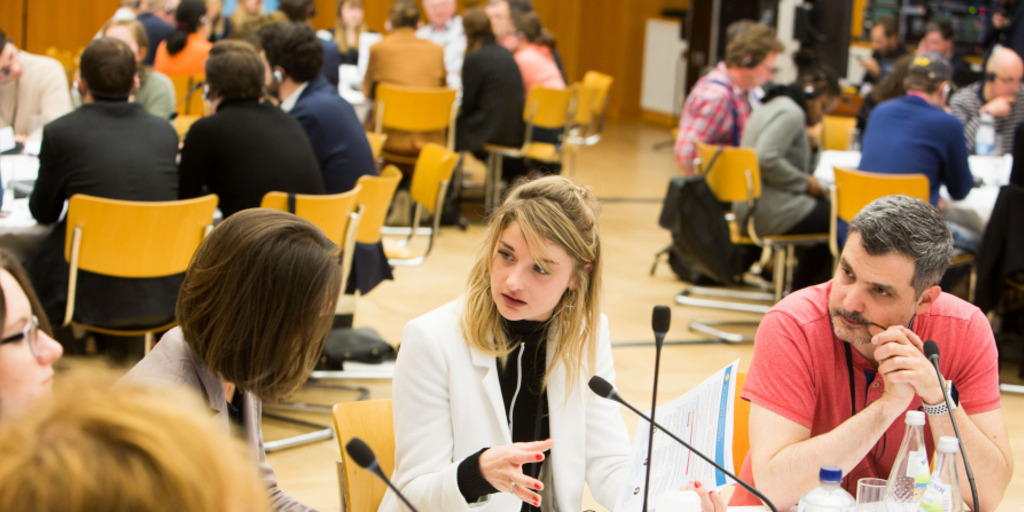Junge Menschen diskutieren am runden Tisch