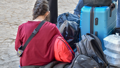 Frau sitzt inmitten von Gepäck