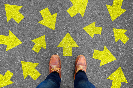 Selfie of shoes and arrows on concrete road