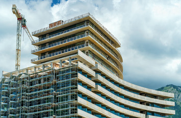 Ein im Bau befindliches Bürogebäude, über dem ein Kran aufragt.