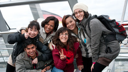 Auf dem Foto sind sechs junge Menschen zu sehen mit verschiedener Herkunft. Sie lachen.
