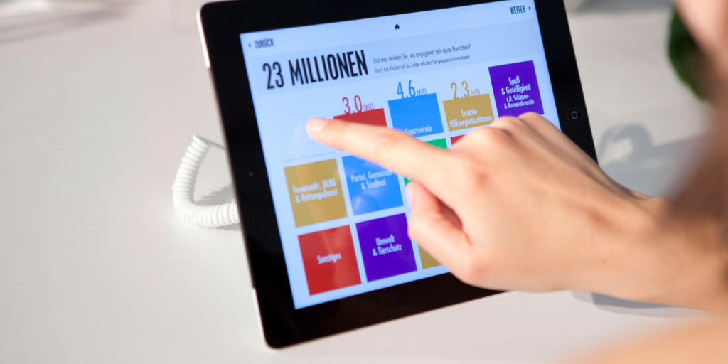 Eine Frau bedient auf einem Tablet eine App der Bertelsmann Stiftung.