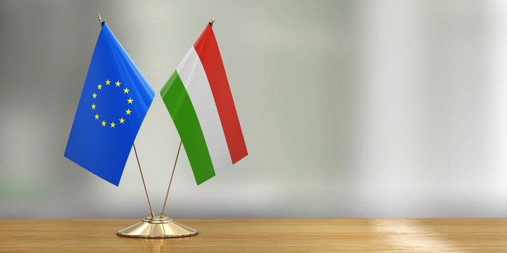 European and Hungarian flag stand side by side on a table